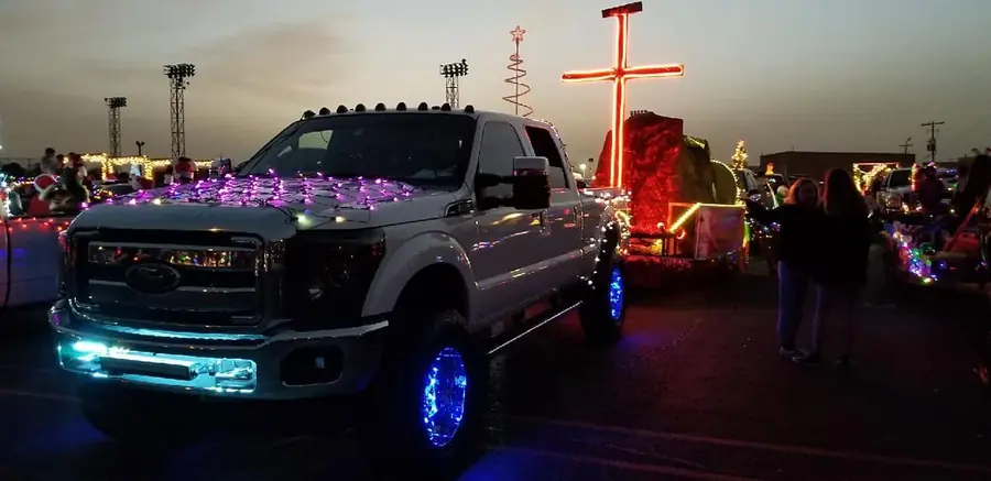 Cross Made Me Ministries parade float with a lit cross display at a community holiday parade